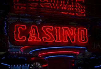 Neon lights display the word 'CASINO' in bright red, standing out against a dark background. The vibrant glow reflects a lively and bustling atmosphere.